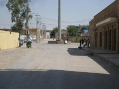 Im Hintergrund scheint ein Hochhaus des modernen Erbil durch das Tor